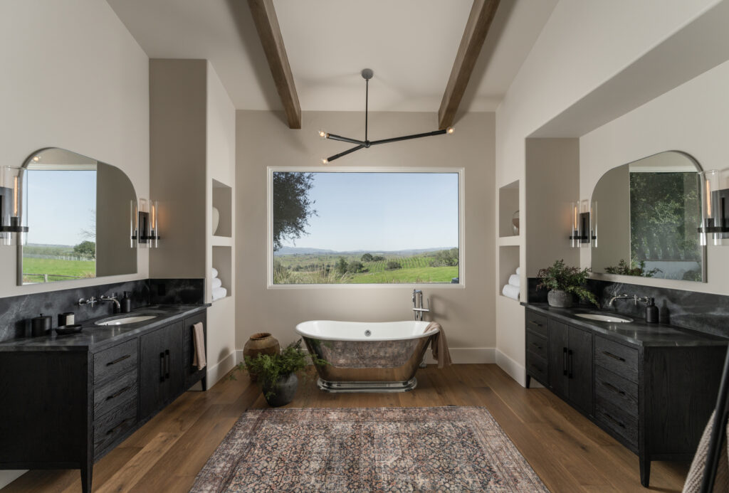 ensuite primary bathroom in Santa Ynez with a view of a vineyard and free standing silver tub