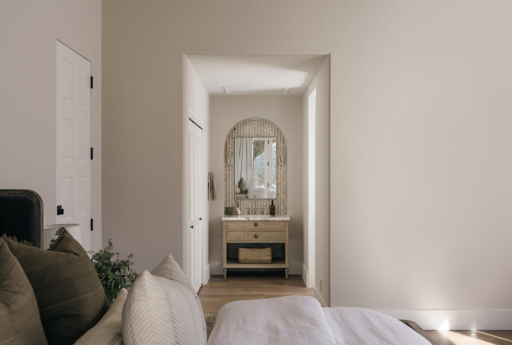 This hotel style vanity sits in the bedroom of a luxury home. It is open to the bedroom and has the same hardwood flooring that was used in the rest of the space.